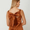 up close of back bow on light brown satin mini dress