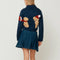 back view of model wearing navy cropped cardigan with cavapoo dog print wearing a red scarf