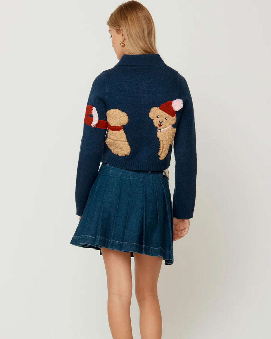 back view of model wearing navy cropped cardigan with cavapoo dog print wearing a red scarf