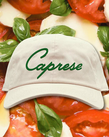 cream hat with green 'caprese' across the front