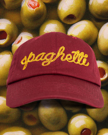 burgundy dad hat with yellow 'spaghetti' typography