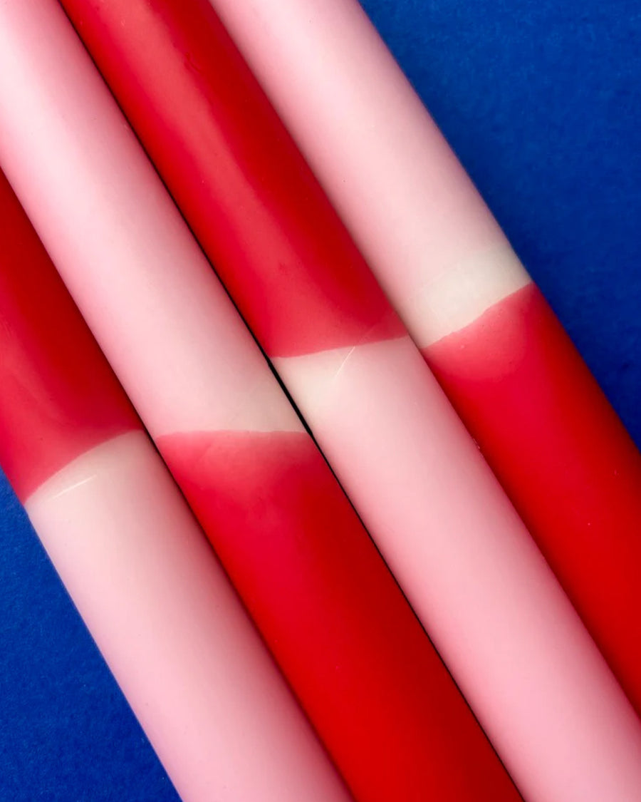 up close of set of 4 red, pink and white layered taper candles