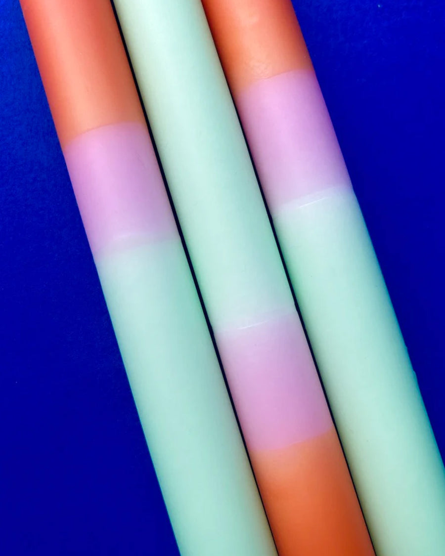 up close of set of 3 orange, mint and pink layered taper candles