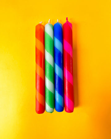 set of 4 diagonally striped taper candles: red/orange, mint/clover green, light blue/royal blue and red/hot pink