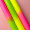 up close of set of 3 pink, lime green and yellow layered taper candles