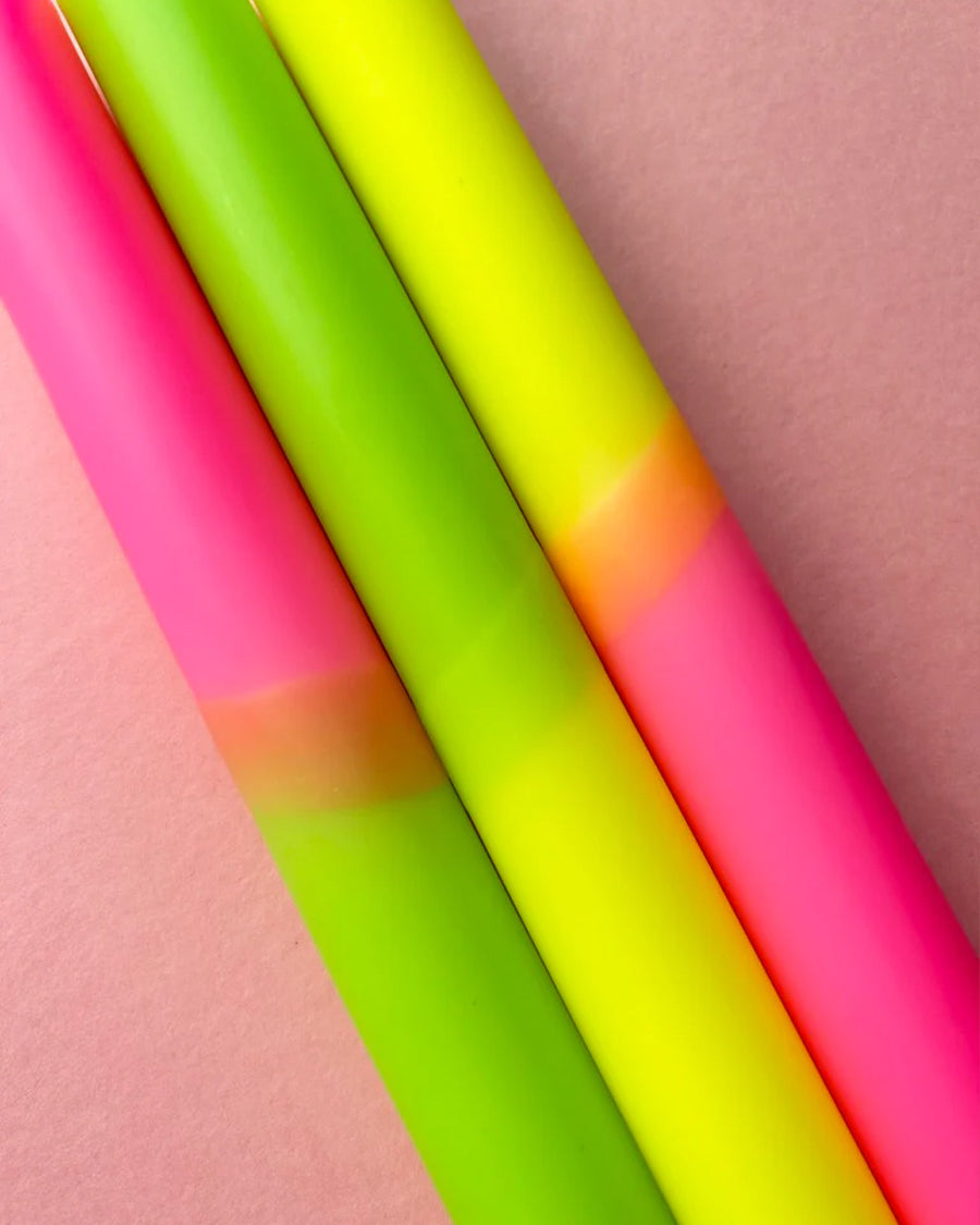 up close of set of 3 pink, lime green and yellow layered taper candles