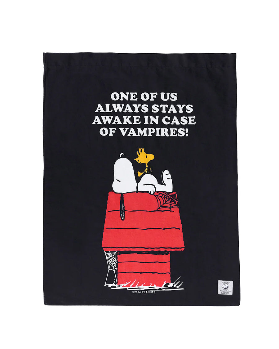 reverse side of black pillowcase style trick or treat bag with snoopy and woodstock on his doghouse and says 'one of use always stays awake in case of vampires!"