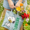 model holding light denim cotton tote with snoopy holding yellow flowers and green 'flowers' on the side