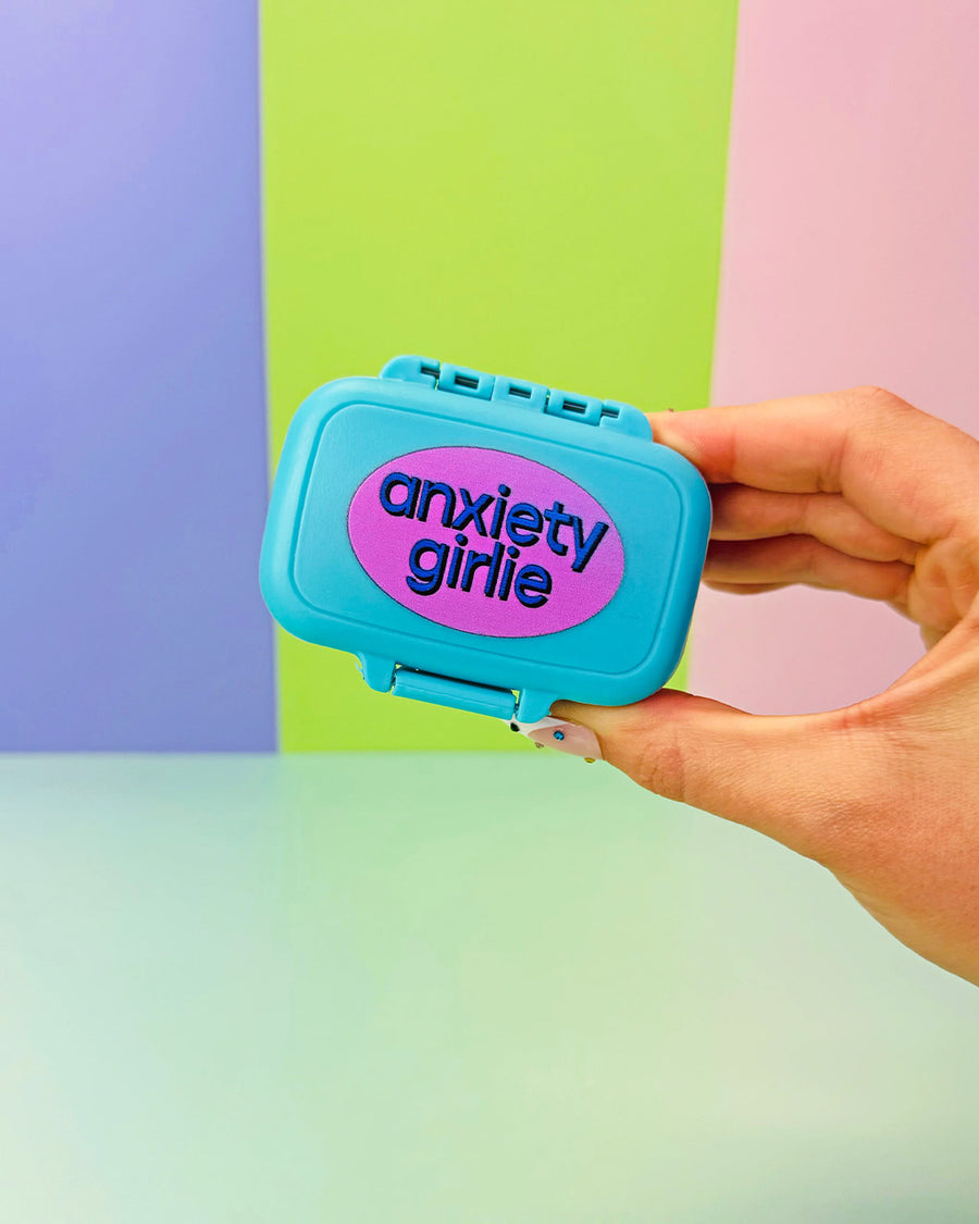 model holding blue pill case with pink circle with 'anxiety girlie' across the front