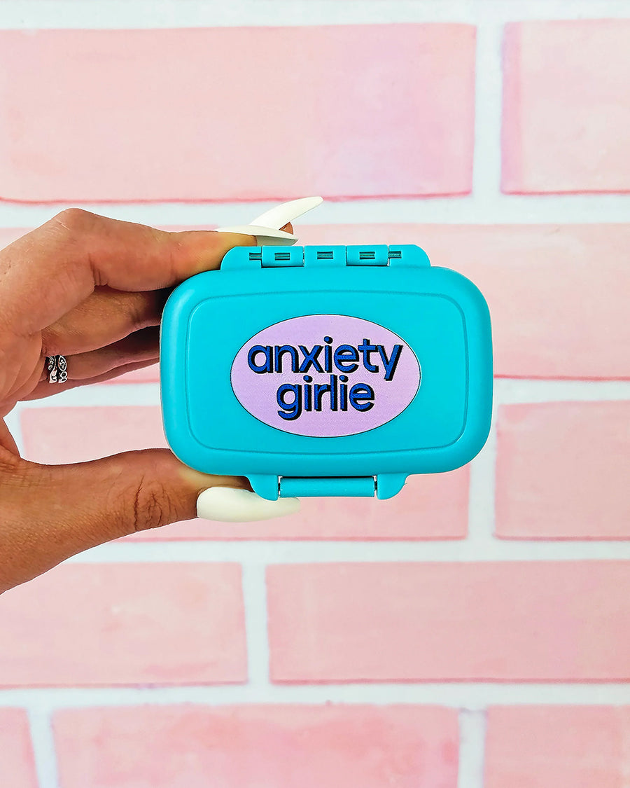 model holding blue pill case with pink circle with 'anxiety girlie' across the front