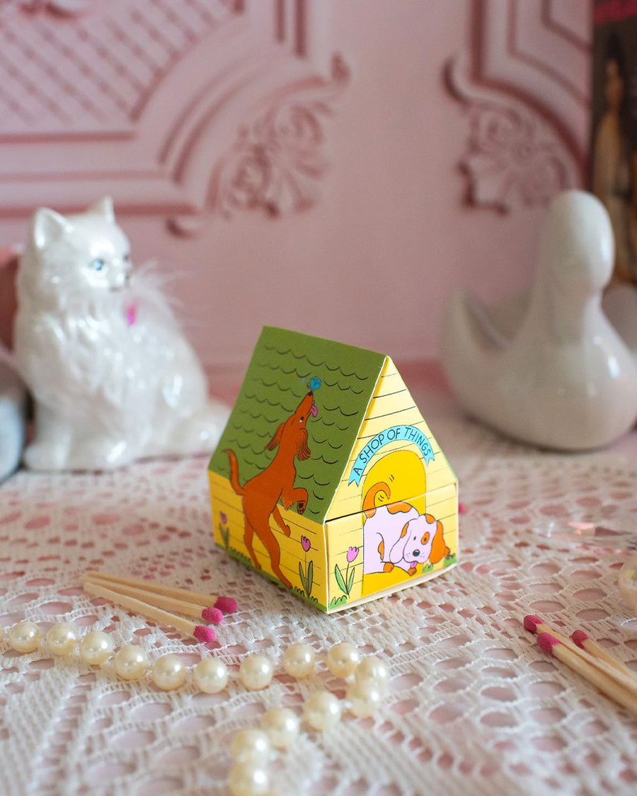 side view of colorful dog house shaped match box with pink tipped matches