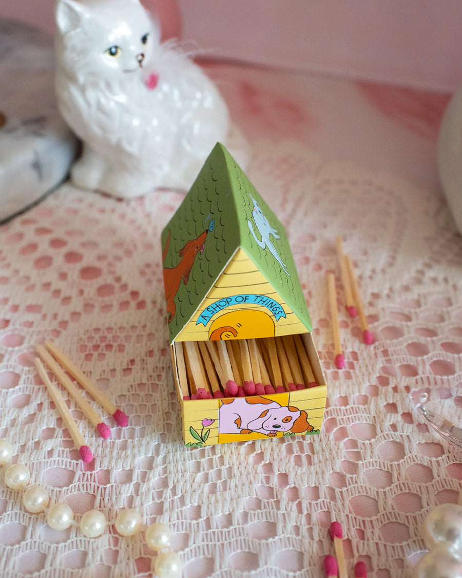 opened drawer on colorful dog house shaped match box with pink tipped matches