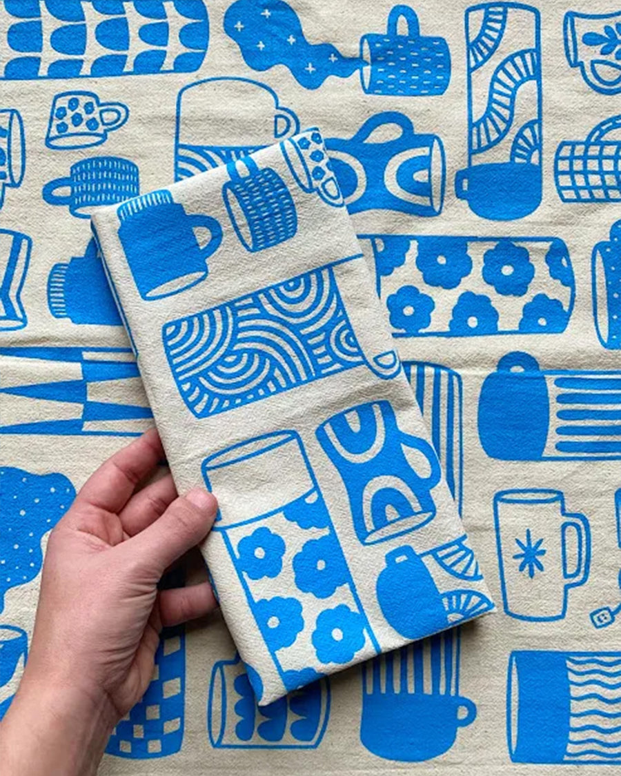 model holding blue 'mug collection' print tea towel