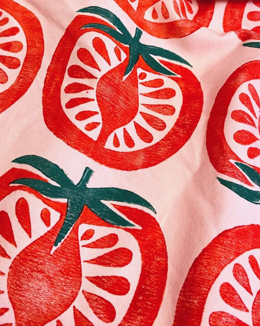 up close of pink tea towel with stamped tomato print