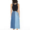 backview of model wearing black tank and light blue and medium blue denim maxi skirt with raw hem waistband