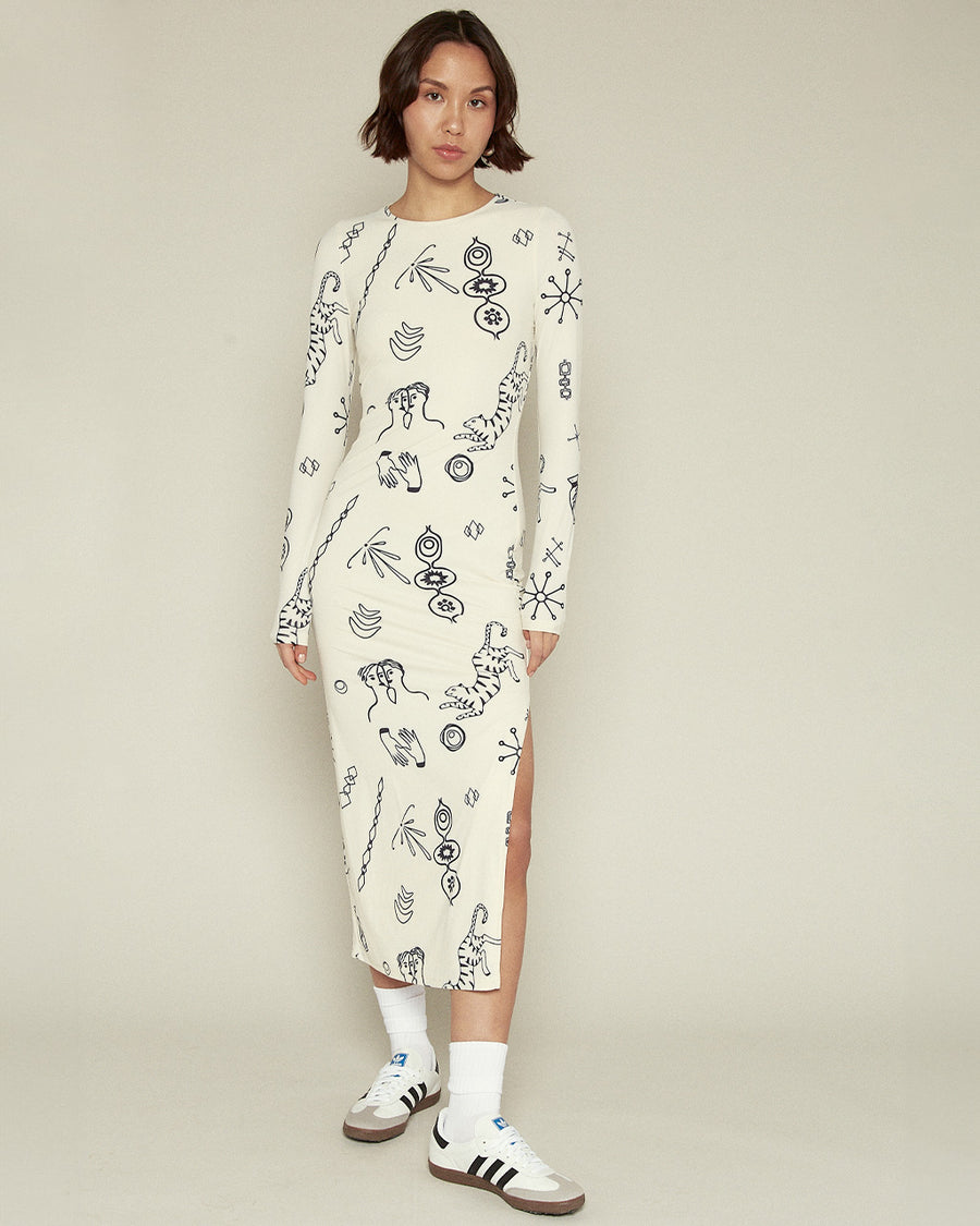 model wearing cream midi dress with long sleeves, side slit, and all over navy 'doodle' print