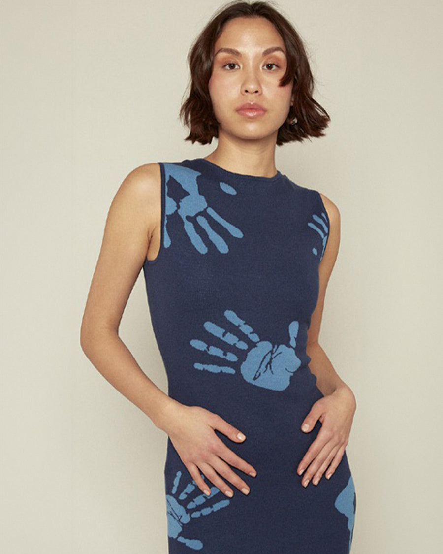 up close of model wearing blue midi dress with all over light blue handprint pattern