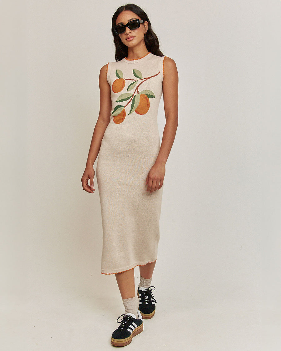 model wearing cream midi knit dress with knitted orange branch print