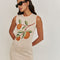 up close of model wearing cream midi knit dress with knitted orange branch print