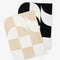 folded set of two trippy checkered hand towels: tan and white and black and white