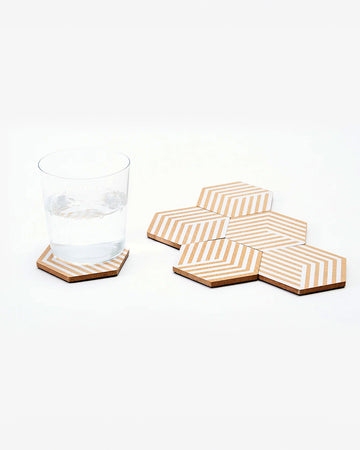 set of six cork and white optical coaster set with a cup on it