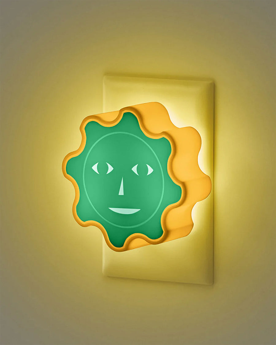 plugged in yellow and green sun face night light