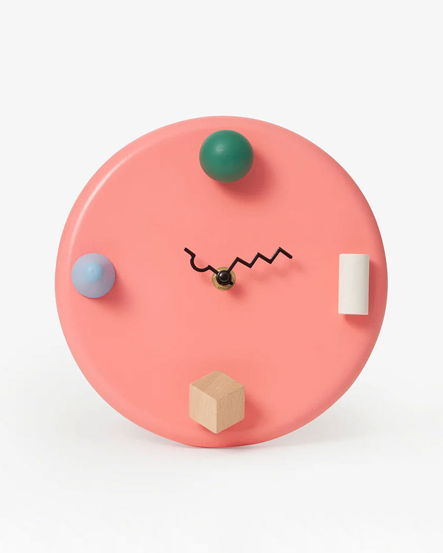 coral wall clock with 3D shapes and squiggle wire hands