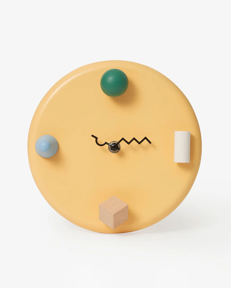 yellow wall clock with 3D shapes and squiggle wire hands