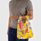 model holding yellow baby baggu with colorful abstract cake and pastry print