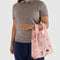 model holding pink baby baggu with various ballet theme icons print