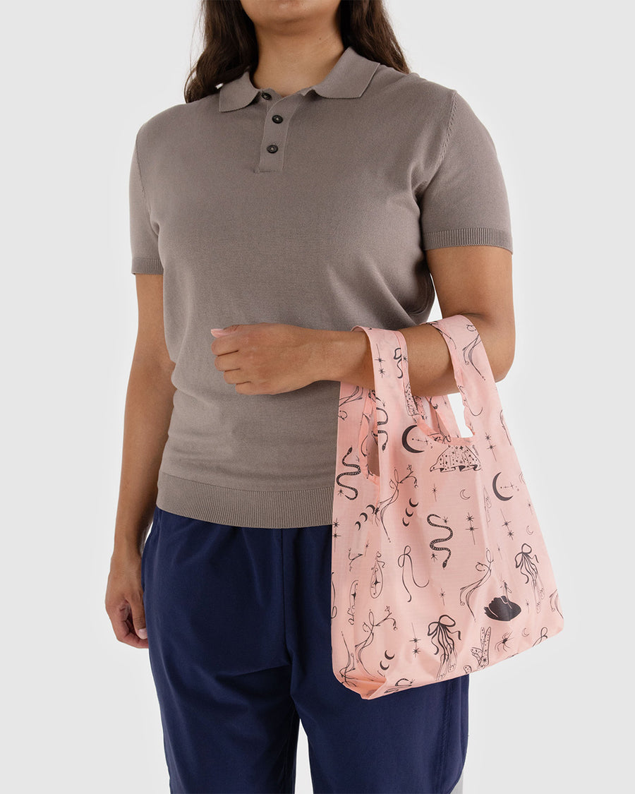 model holding pink baby baggu with various ballet theme icons print