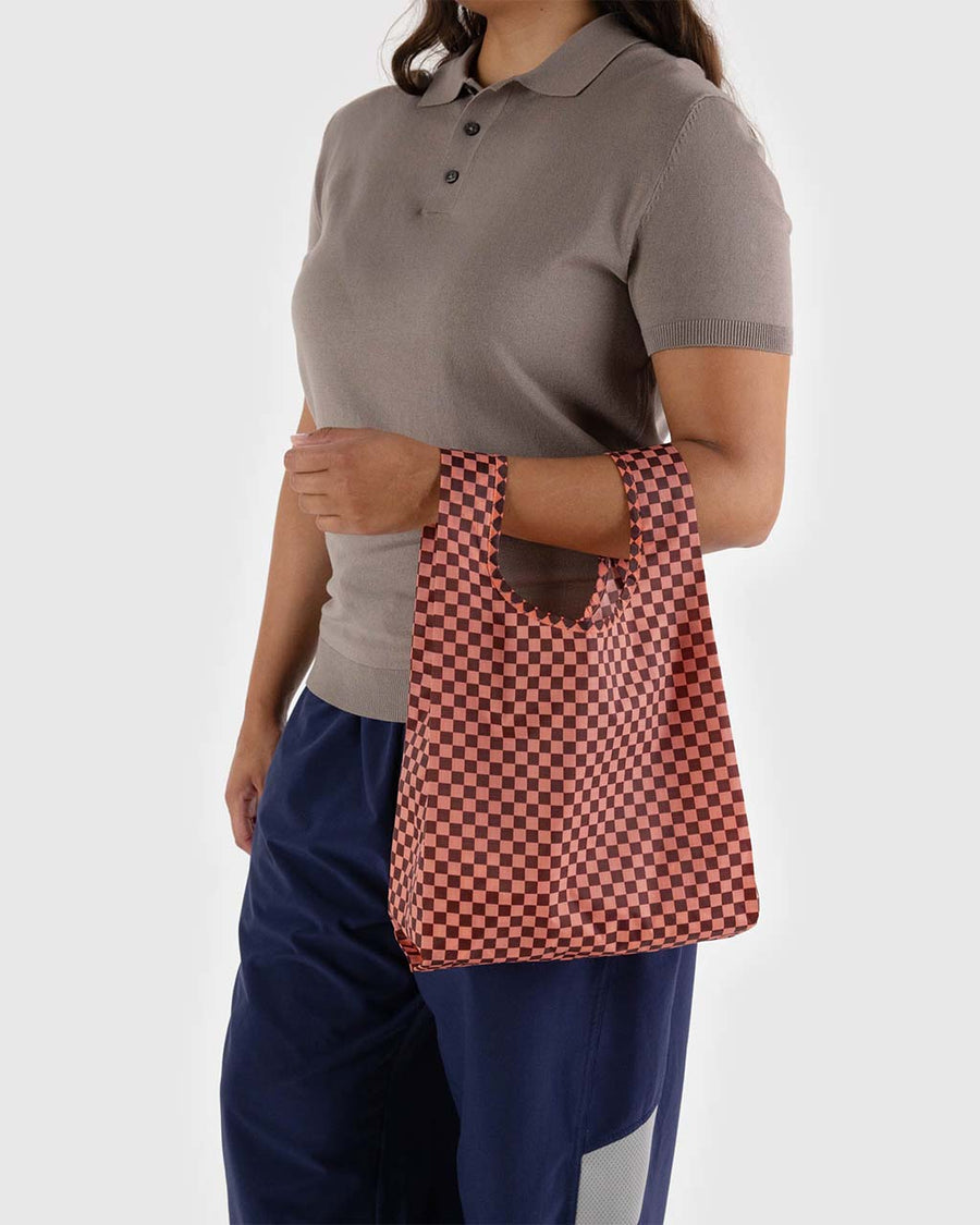 model holding pink and brown checkered baby baggu