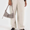 model holding taupe cargo shoulder bag with two front patch pockets in the front