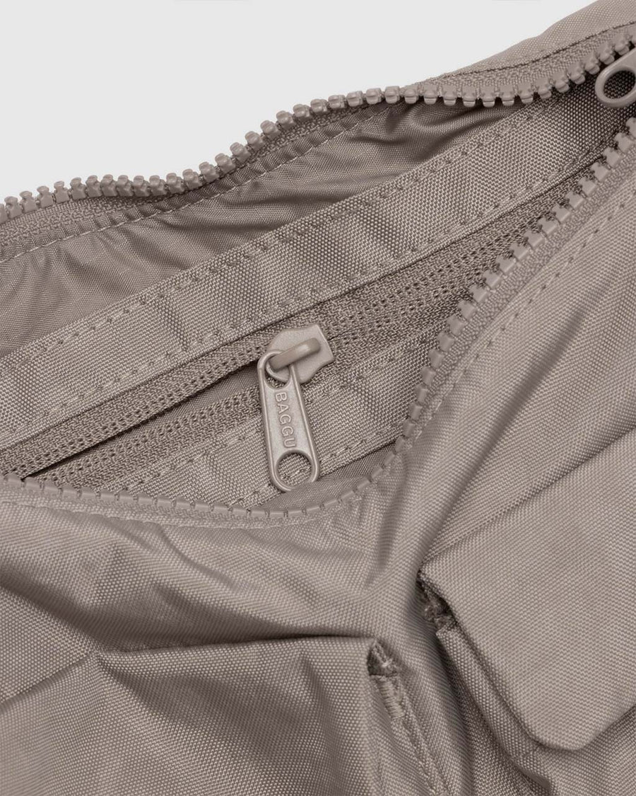 interior compartment of taupe cargo shoulder bag with two front patch pockets in the front