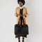 model holding black cloud carry on bag