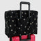 black baggu cloud carry on bag with silver metallic star print on a suitcase