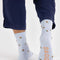 back view of model wearing blue crew socks with dainty yellow floral design