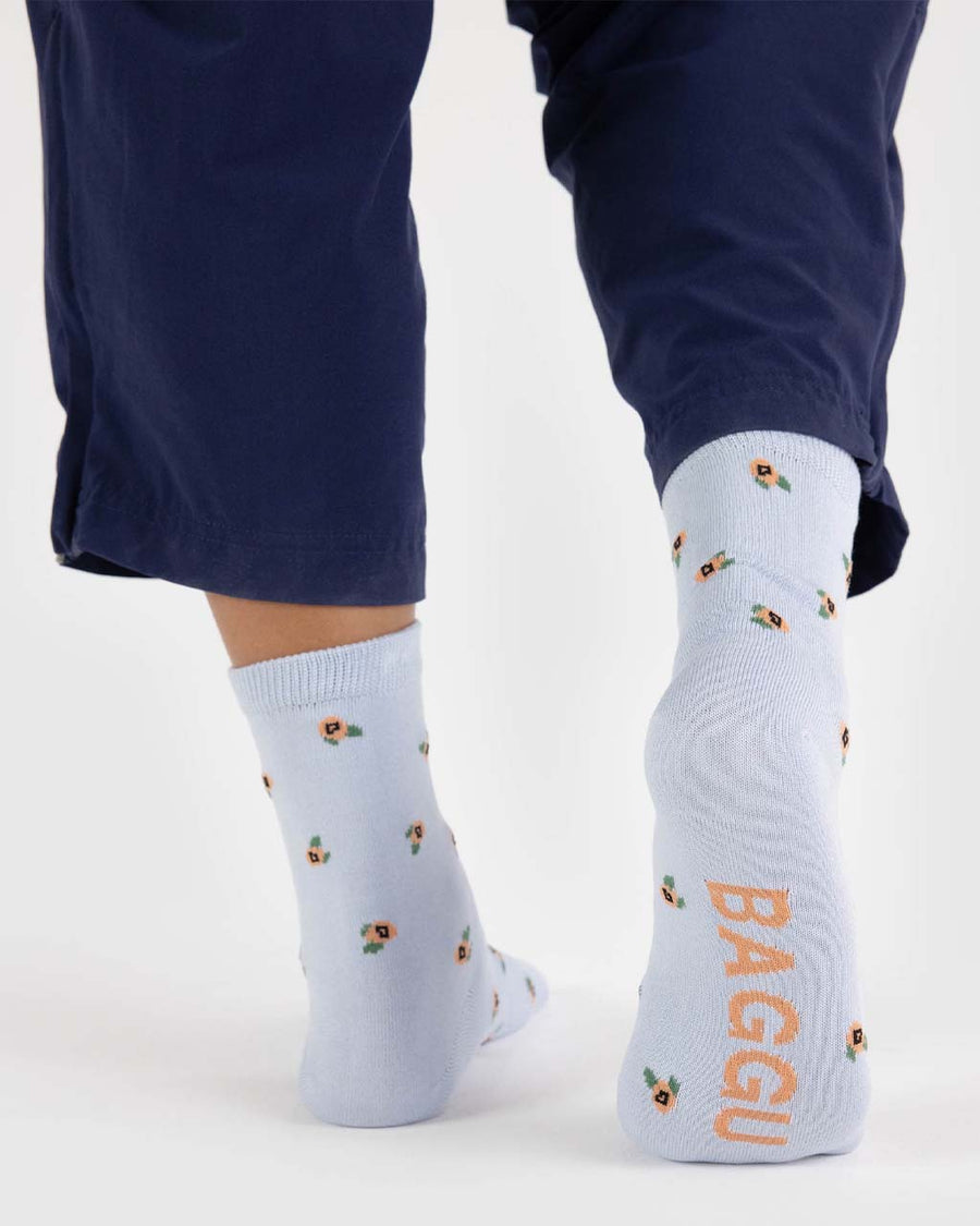 back view of model wearing blue crew socks with dainty yellow floral design