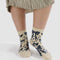 model wearing cream crew socks with navy cherub and bow print