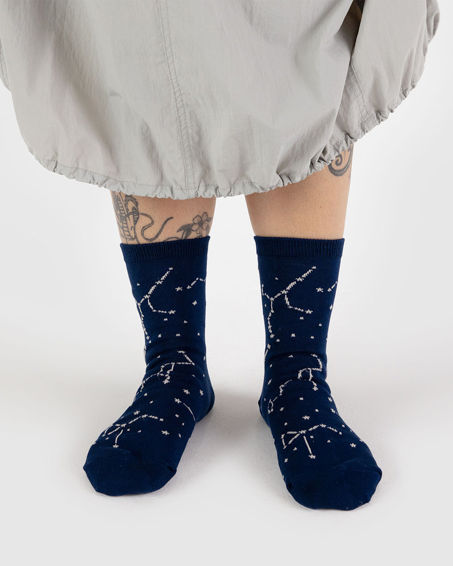 model wearing dark blue crew socks with white constellation print