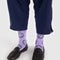 model wearing lavender crew socks with all over green smiley print