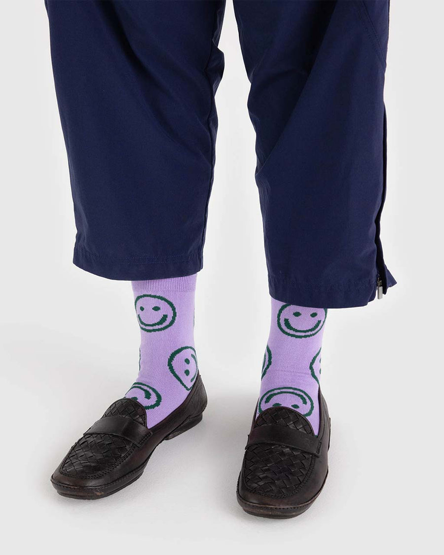 model wearing lavender crew socks with all over green smiley print