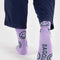 backview of lavender crew socks with all over green smiley print