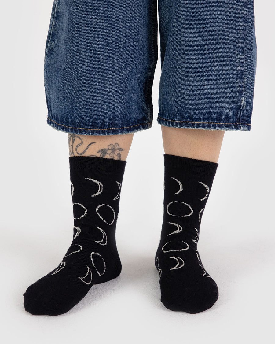 model wearing black crew socks with white moon phase print