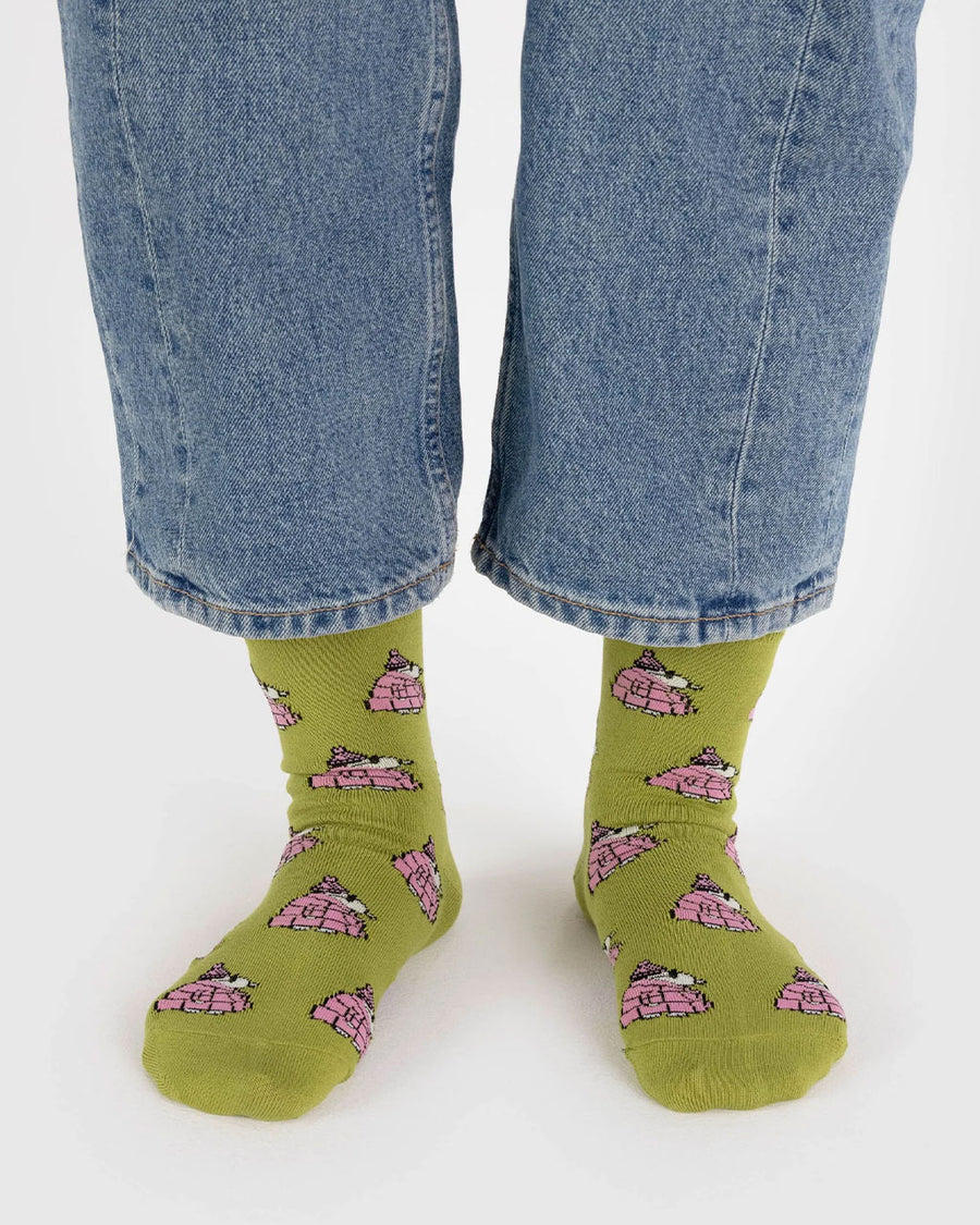 model wearing avocado green crew socks with snoopy in a pink puffer coat