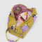 mustard yellow dopp kit with snoopy in a pink puffer coat and hat with items inside