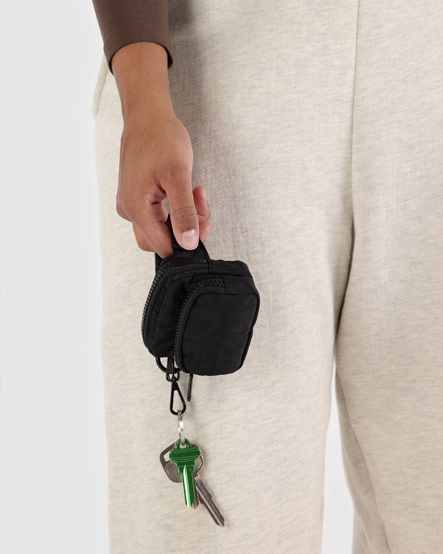 model holding black mini baggu fanny pack keychain