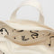 interior of cream horiztonal zip bag with black embroidered ballet icons design