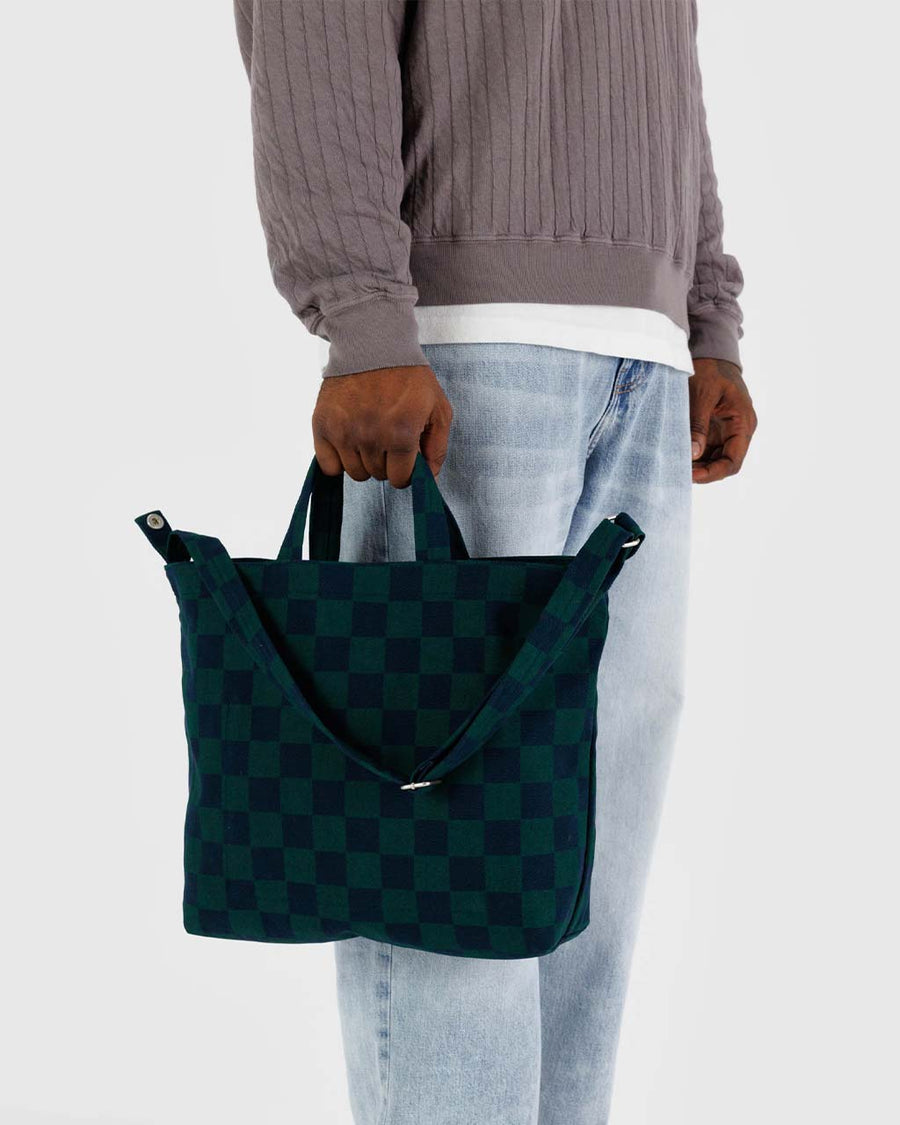 model holding navy and dark green horizontal zip duck bag