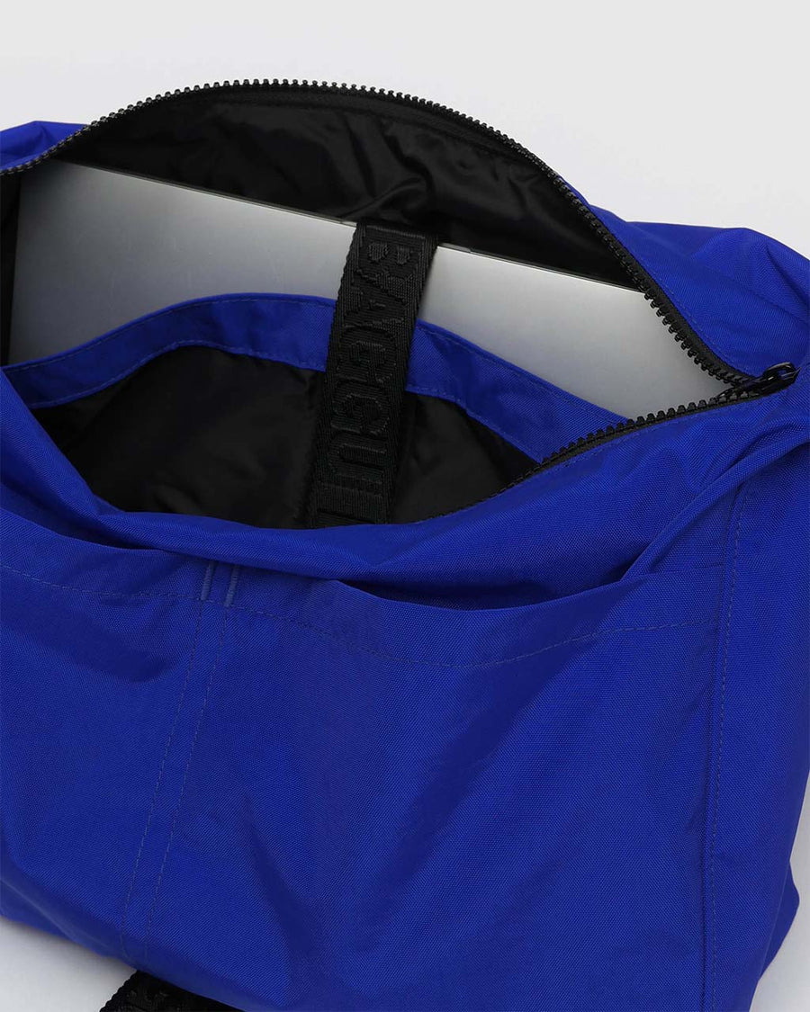 interior of bright blue large messenger bag with black strap and closure 